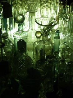 an assortment of glass bottles sitting on top of a table next to eachother