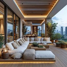 an outdoor living area with couches, tables and potted plants on the deck