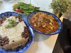 two plates filled with food sitting on top of a table next to another plate full of food