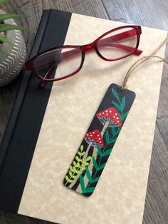 a pair of red glasses sitting on top of a book next to a green plant