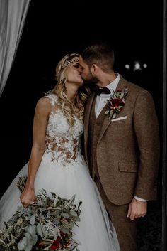 a bride and groom kissing in front of a window