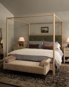 a bedroom with a four poster bed and two night stands