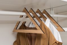 clothes hangers with shirts hanging on them in a closet