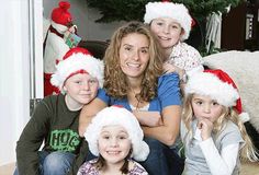 a woman and her children wearing christmas hats