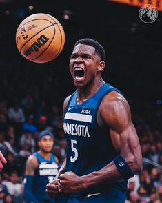 a basketball player with his mouth open in front of a ball that is flying through the air