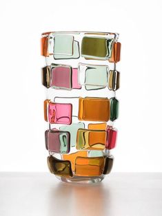 a colorful glass vase sitting on top of a table