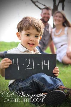 a young boy holding up a chalk board with the number twenty - four written on it