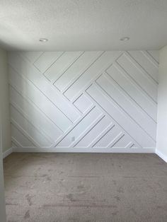 an empty room with white painted walls and carpet