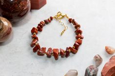 This Red Jasper gemstone chip bracelet is made with care and attention to detail using gorgeous tumbled Red Jasper chips arranged in a graduated size design for an attractive look. The Jasper is interspersed with 2mm gold filled beads. The bracelet is 18 cm long and is fastened using a gold plated lobster claw clasp and 25mm extension chain for an adjustable fit. The bracelet is constructed using  19 strand beading wire making it both flexible yet very strong. Red Japer is widely regarded as an Gemstone Chips Bracelet, Semi Precious Stone Bracelet, Chip Bracelet, Earthy Jewelry, Crystal Healing Bracelets, Memory Wire Bracelets, Citrine Crystal, Lava Bead, Beading Wire