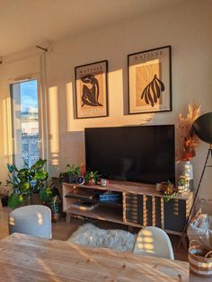 a living room filled with furniture and a flat screen tv on top of a wooden table