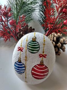 an ornament with ornaments on it next to pine cones