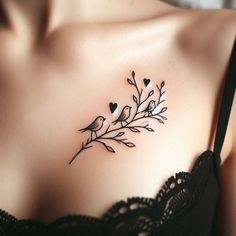 a woman's chest with two birds on the branch and hearts in the middle