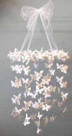 a bunch of white butterflies hanging from a ceiling