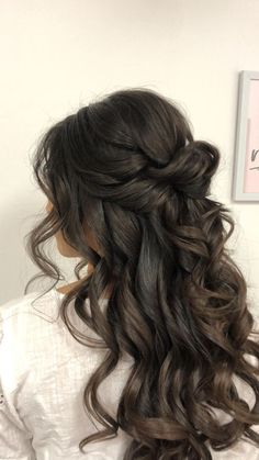 the back of a woman's head with long dark hair and curls in it