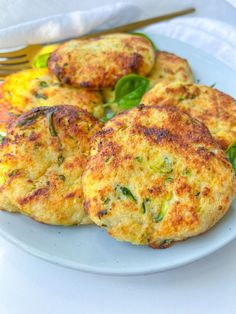 three crab cakes on a plate with a fork