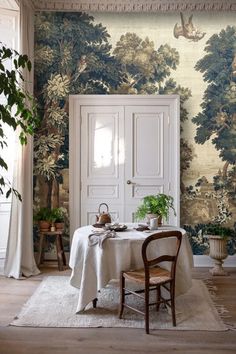 a dining room with a table and chairs in front of a painting on the wall