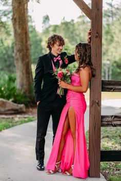 a man in a tuxedo standing next to a woman in a pink dress