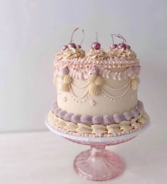 a three layer cake with pink frosting and cherries on top