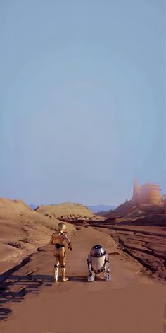 two people walking down a dirt road in the desert with a robot on one side