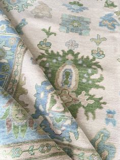 an upholstered fabric with blue and green floral designs on white groundcloths