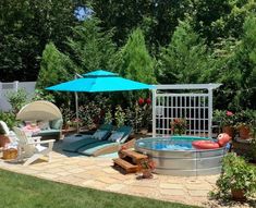 an outdoor hot tub in the middle of a yard with patio furniture and umbrellas