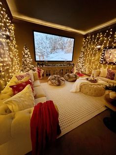 a living room decorated for christmas with lights on the walls and a large screen in the corner