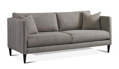 a gray couch with two pillows on it's back and one arm facing the camera