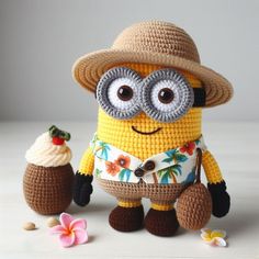 a crocheted minion holding an ice cream sundae and wearing a straw hat