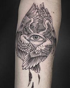 an all seeing eye tattoo on the left arm with wings and feathers around it,