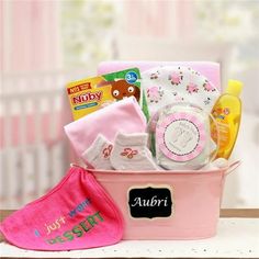 a pink baby gift basket with personalized items in it, including socks and diapers