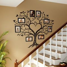 a family tree wall hanging on the side of a stair case next to a banister