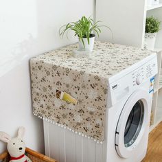 a white washer sitting on top of a wooden floor next to a dryer