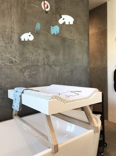 a white bath tub sitting in a bathroom next to a wall with elephants on it