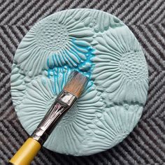 a paintbrush sitting on top of a blue plate