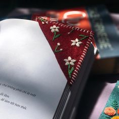 an open book with embroidered flowers on it