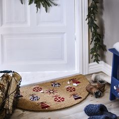 a dog is laying on the floor next to a christmas wreath and doormats