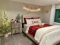 a bedroom decorated for christmas with lights strung from the ceiling and decorations on the bed