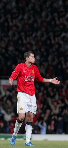 a man in red shirt playing soccer on field