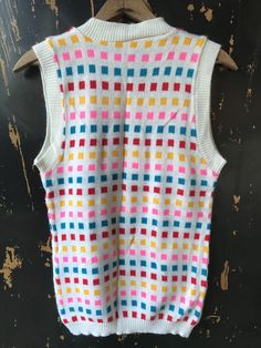 "Fantastic vintage 60's/70's mod colorful square pattern knit sleeveless sweater top. Longer fit, but can be tucked in nicely. 100% acrylic. In good vintage condition. Made by RJ Pumpkin. Will best fit medium. Measurements laying flat: fabric stretches Armpit to armpit: 18\" Length: 25\"" Fitted Multicolor Sweater Vest For Fall, Multicolor Sleeveless Sweater Vest For Fall, Multicolor Sleeveless Top For Fall, Multicolor Sleeveless Vest For Fall, Multicolor Retro Summer Vest, Retro Multicolor Summer Vest, White Fitted Retro Sweater Vest, Retro Knit Color Block Tops, Retro Cotton Sleeveless Sweater Vest