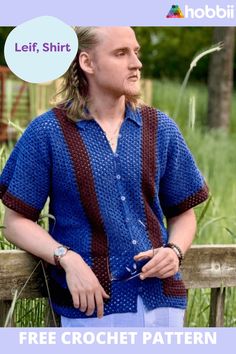 a man standing next to a fence wearing a blue shirt with brown stripes on it