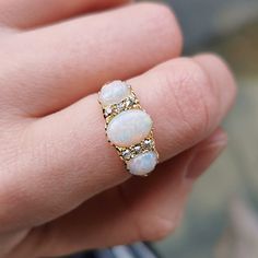 A beautiful antique ring, set with three oval-shaped cabochon opals, with a total of six old-cut diamonds set in-between, mounted in 18ct yellow gold, in a classic carved claw setting. With British hallmarks dating the ring to 1906. Hallmarked as 18ct gold, dated Birmingham 1906. The approximate weight is 4.6 grams. Please note the antique ring box pictured is for display purposes only. Thank you. Ring size K (UK) or 5 1/8 (US) - this ring can be adjusted in size in our workshop. Please get in touch to discuss sizing options and lead time. For UK to US ring size conversions we use www.ringsizes.co as our reference chart. CONDITION: In overall very good antique condition, with some light wear commensurate with age. LAYAWAY: We happily offer layaway/deposits on the majority of our items. Ple Oval Three Stone Opal Ring Fine Jewelry, Oval Opal Rings With Rose Cut Diamonds, Classic Three Stone Oval Opal Ring, Gold Opal Three-stone Oval Ring, Gold Oval Three-stone Opal Ring, Gold Oval Three Stone Opal Ring, Gold Oval Opal Ring With Three Stones, Antique Ring Box, Opal Diamond Ring