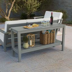 an outdoor table with drinks and snacks on it