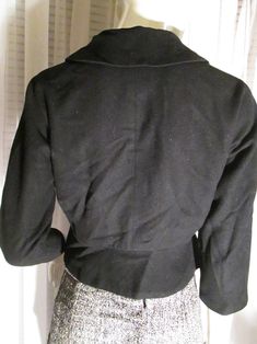 "1950's ladies petite waist clinching little jacket made in Italy. Front plastic front buttoned, big flip collar, flap back waistline with side buttoned flaps, dolman sleeves, rayon fully lined, in light wool fabric. Jacket outside is in good condition, but black rayon lining is slightly aging color changed, the buttons have a center scratch where maybe they once had a stone or something in each center . Bust about 36\"-38\", Waist 28\", Neckline about 14 1/2, and Jacket Length 19\". PRICE is $3 Fitted Double-breasted Cropped Jacket With Buttons, Fitted Wool Cropped Jacket For Office, Elegant Fitted Wool Cropped Jacket, Classic Cropped Jacket For Winter Formal Events, Classic Winter Cropped Jacket For Formal Occasions, Fitted Cropped Jacket With Lapel Collar And Buttons, Formal Fitted Button-up Pea Coat, Classic Fitted Cropped Jacket With Button Closure, Classic Fitted Double-breasted Cropped Jacket