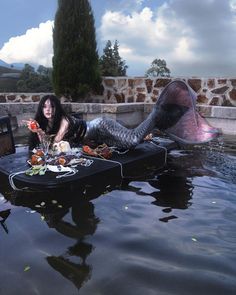 a woman laying on top of a table in the water