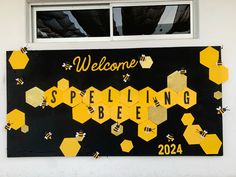 a welcome sign with bees and honeycombs painted on the side of a building