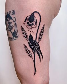 a woman's thigh with a bird and flower tattoo on her left side calf