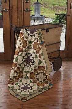 a dog sitting in a wagon with a quilt on it