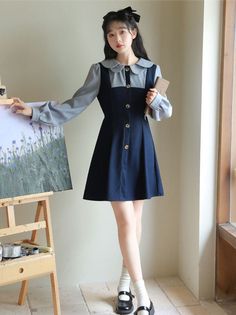 Faux two-piece pinafore blouse dress with a scallop collar, button front and mini twirl skirt. Concealed back zipper with waist ties. S: 14" across shoulders, 35" chest, 28" waist, 32" lengthM: 14.5" across shoulders, 36.5" chest, 29.5" waist, 32" lengthL: 15" across shoulders, 38" chest, 31" waist, 32" length Long Sleeve Suspender Dress For Spring, Preppy Mini Dress For Fall, Spring Workwear Pinafore Dress With Buttons, Spring School Dresses With Buttons, Workwear Dress With Peter Pan Collar And Buttons, Fitted Mini Length Pinafore Dress For Fall, Scallop Collar, Twirl Skirt, Collared Dress