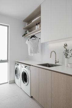 a washer and dryer sitting in a kitchen next to an open sink window