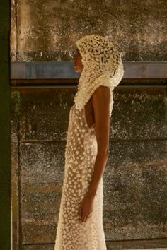 a woman in a white dress is walking down the street